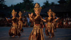 Penari tarian budaya Indonesia tampil di panggung terbuka saat senja.